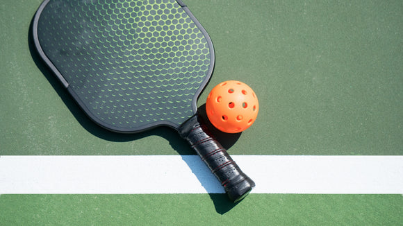 A pickleball paddle and a pickleball