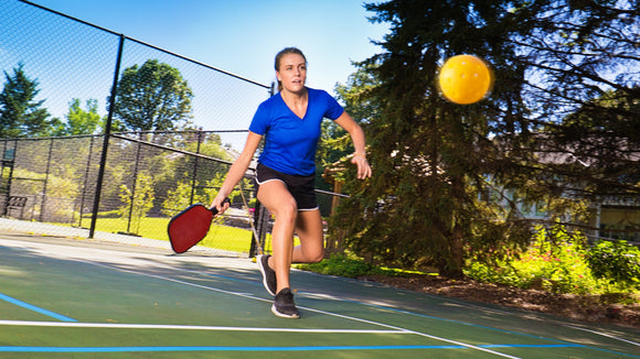 An On-court Engage Pickleball Pro Player about to hit the ball