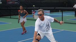 Steve Kennedy, a Senior Pro Pickleball Champion, mid-swing during a competitive pickleball match, showcasing his athletic form and concentration on the court.