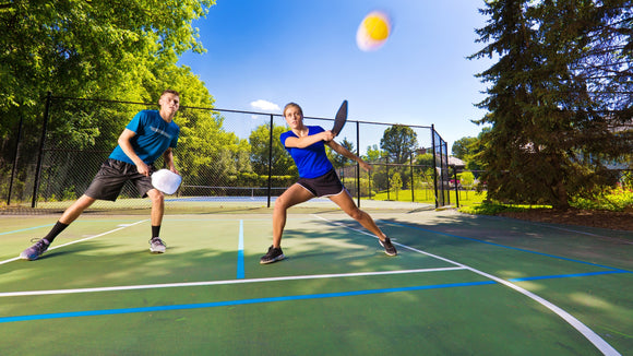 A couple of on-court Engage Pickleball Pro players taking a defense